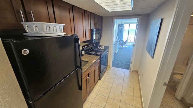 1105 S Ocean Blvd Unit 236, Myrtle Beach, SC 29577 - kitchen featuring black appliances, light tile patterned floors, and stone counters