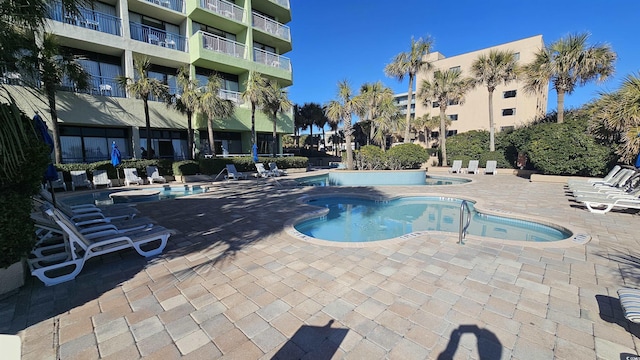 view of swimming pool with a community hot tub and a patio area