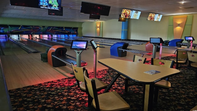 recreation room featuring a paneled ceiling, bowling, and hardwood / wood-style floors