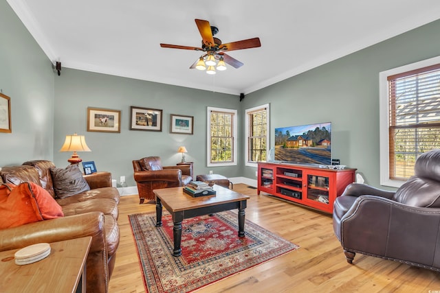 living room featuring a wealth of natural light, ornamental molding, and light wood-type flooring