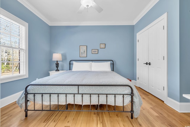 bedroom featuring ornamental molding, a closet, ceiling fan, and light wood-type flooring