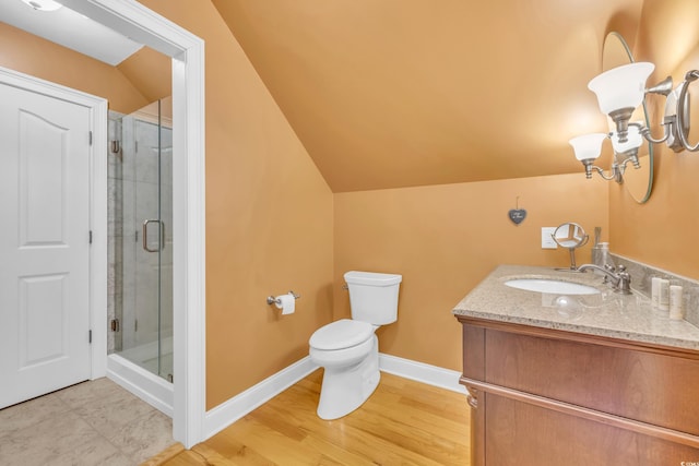 bathroom featuring a shower with door, vanity, vaulted ceiling, and toilet