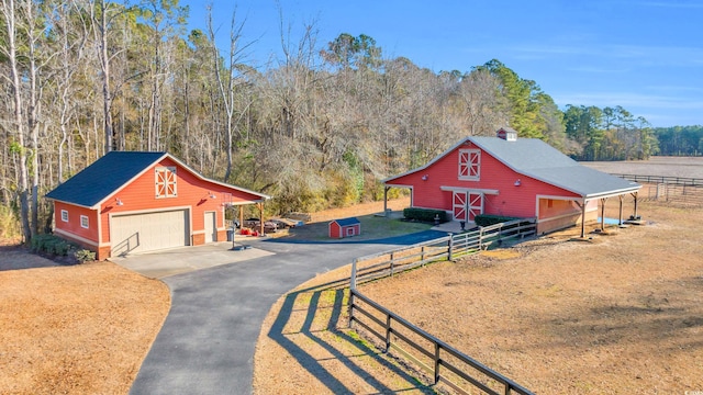 exterior space with a garage, a lawn, and a rural view