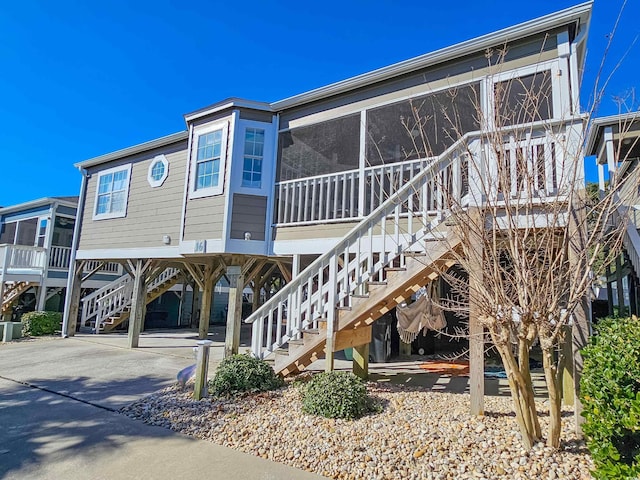 299 Lake Arrowhead Rd, Myrtle Beach, SC 29572 - rear view of house with a carport, stairs, a sunroom, and concrete driveway
