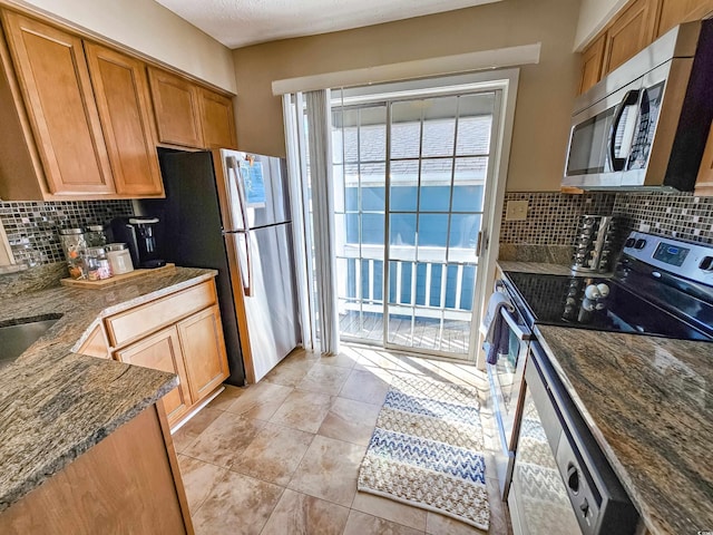 299 Lake Arrowhead Rd, Myrtle Beach, SC 29572 - kitchen with appliances with stainless steel finishes, tasteful backsplash, dark stone countertops, and light tile patterned floors