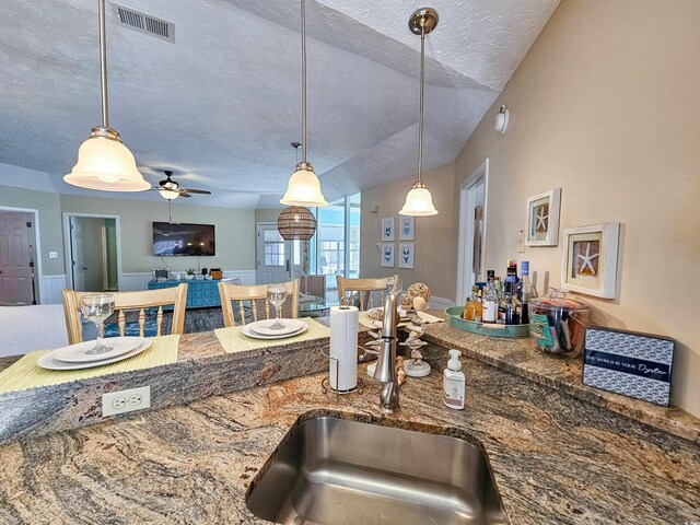 299 Lake Arrowhead Rd, Myrtle Beach, SC 29572 - kitchen with a textured ceiling, stone counters, pendant lighting, open floor plan, and ceiling fan