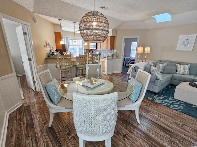 299 Lake Arrowhead Rd, Myrtle Beach, SC 29572 - dining area with a textured ceiling, a wainscoted wall, dark wood-style flooring, and a skylight