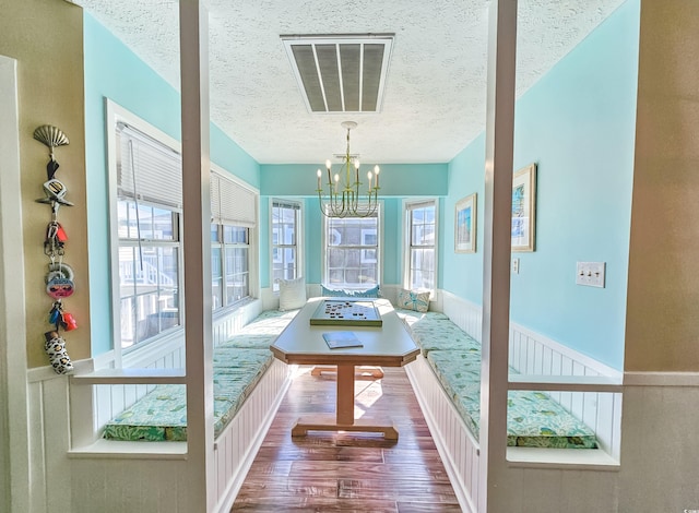 299 Lake Arrowhead Rd, Myrtle Beach, SC 29572 - dining space with a textured ceiling, a chandelier, wood finished floors, and wainscoting