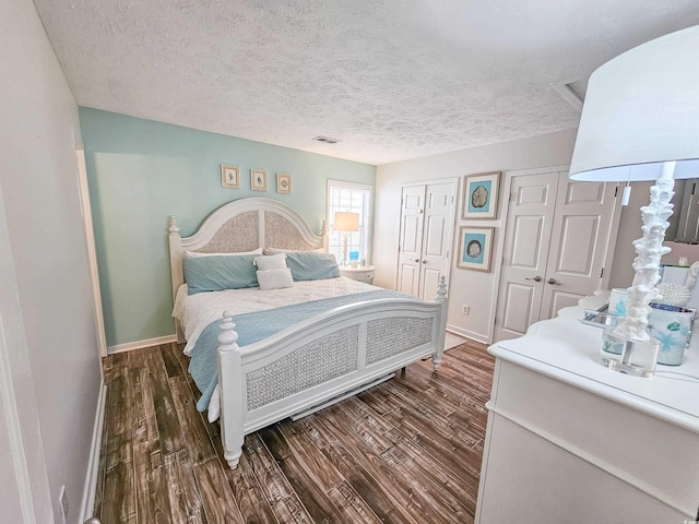 299 Lake Arrowhead Rd, Myrtle Beach, SC 29572 - bedroom with dark wood-style flooring, multiple closets, and a textured ceiling
