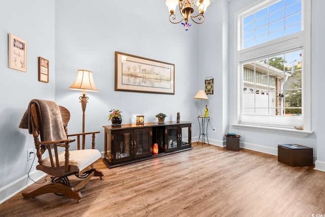 living area with hardwood / wood-style floors and a chandelier