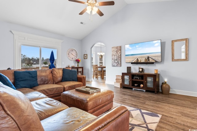 living room with hardwood / wood-style flooring, ceiling fan with notable chandelier, and high vaulted ceiling