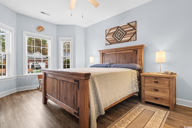 bedroom with dark hardwood / wood-style flooring and ceiling fan