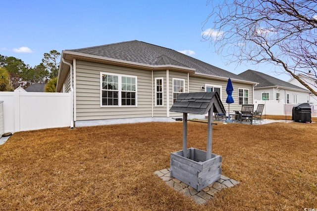 rear view of property featuring a yard and a patio area