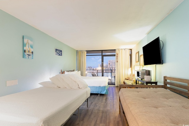 bedroom featuring dark wood-type flooring, a wall of windows, and access to outside