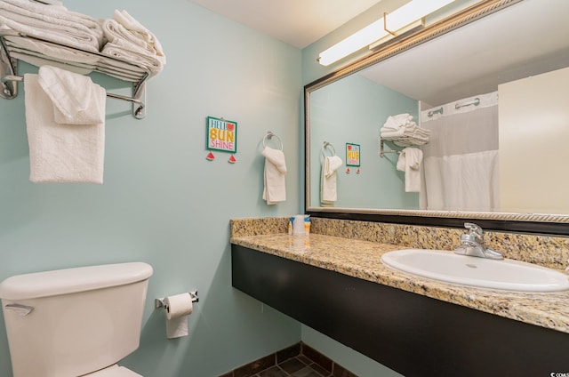 bathroom featuring walk in shower, vanity, and toilet