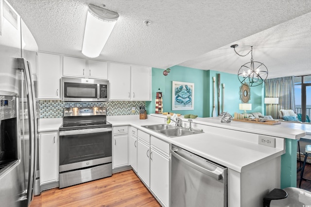 501 S Ocean Blvd Unit 505, North Myrtle Beach, SC 29582 - kitchen with a peninsula, stainless steel appliances, light countertops, a textured ceiling, and tasteful backsplash