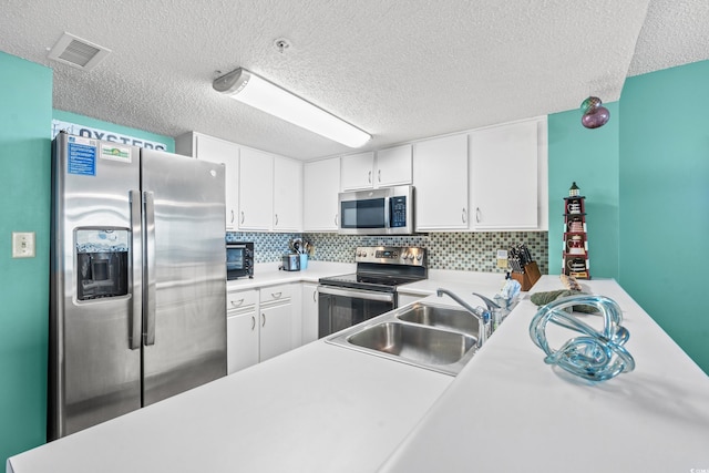 501 S Ocean Blvd Unit 505, North Myrtle Beach, SC 29582 - kitchen featuring stainless steel appliances, light countertops, white cabinets, a textured ceiling, and decorative backsplash