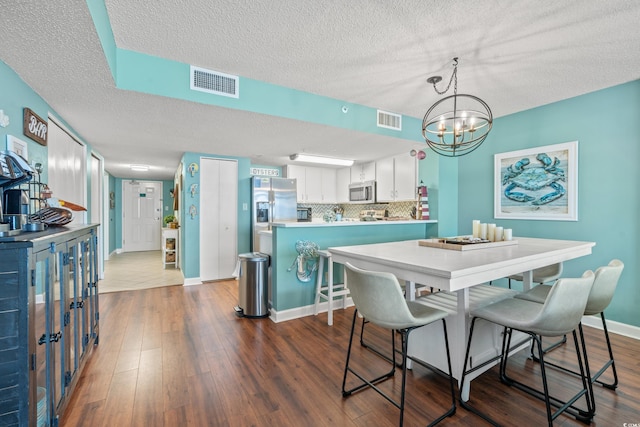 501 S Ocean Blvd Unit 505, North Myrtle Beach, SC 29582 - dining space featuring a textured ceiling, dark wood finished floors, and a chandelier