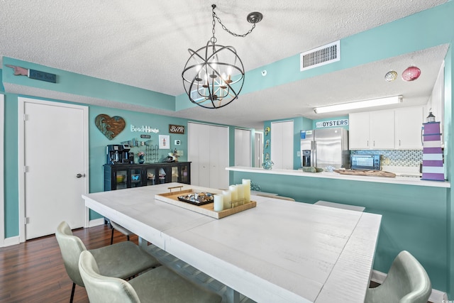 501 S Ocean Blvd Unit 505, North Myrtle Beach, SC 29582 - dining room with a textured ceiling, a chandelier, and dark wood-type flooring