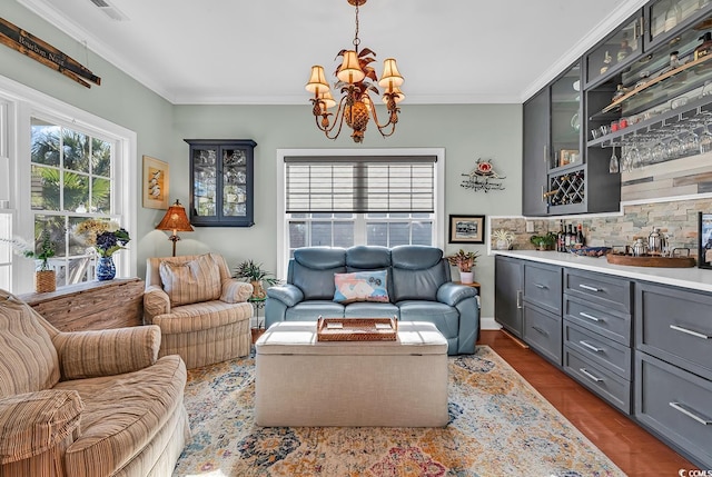 living room featuring crown molding, dark hardwood / wood-style floors, and a chandelier