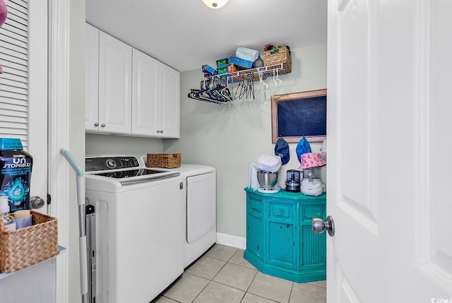 laundry area with cabinets, washing machine and dryer, and light tile patterned flooring