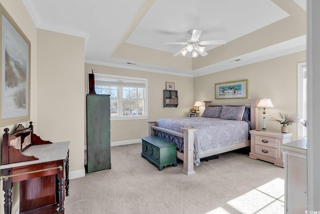 bedroom featuring ornamental molding, light carpet, ceiling fan, and a tray ceiling