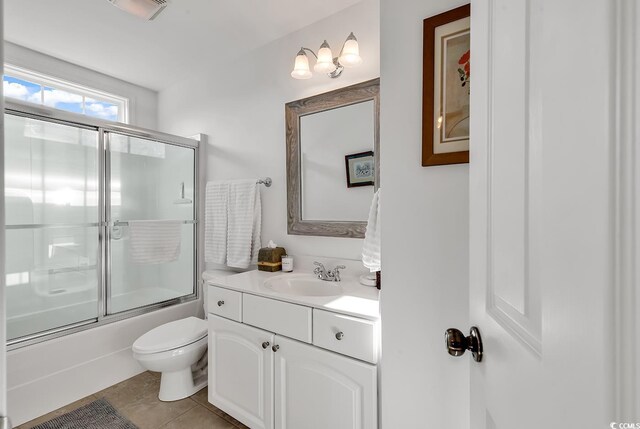 full bathroom featuring vanity, tile patterned floors, enclosed tub / shower combo, and toilet