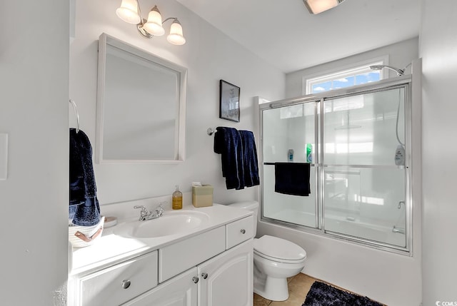 full bathroom featuring enclosed tub / shower combo, vanity, toilet, and tile patterned floors