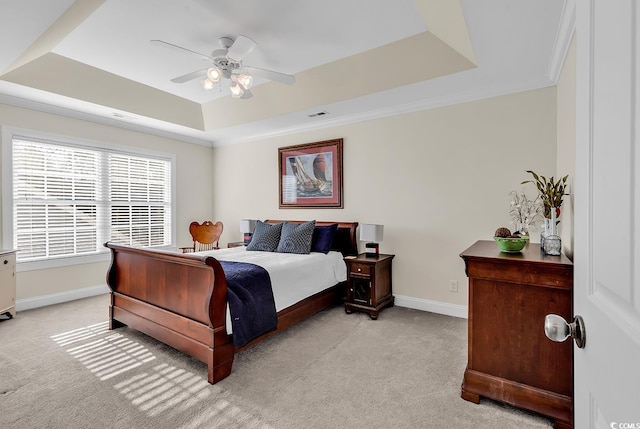 carpeted bedroom featuring ceiling fan, ornamental molding, and a raised ceiling