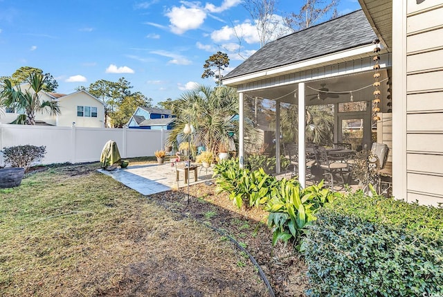 view of yard with a sunroom, ceiling fan, and a patio area