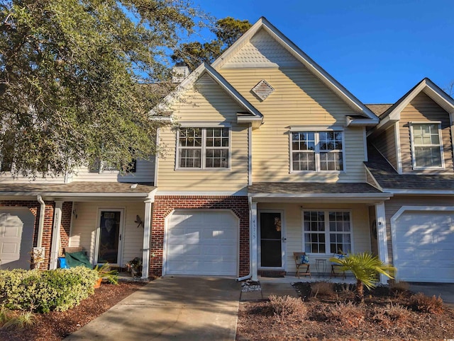 traditional-style home with a porch, brick siding, driveway, and an attached garage