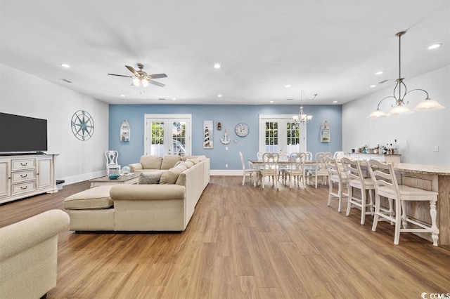 living room with light hardwood / wood-style flooring, ceiling fan, and french doors