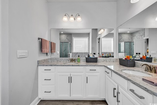 bathroom featuring a shower with door and vanity