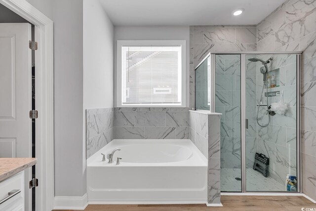 bathroom with hardwood / wood-style flooring, vanity, and independent shower and bath