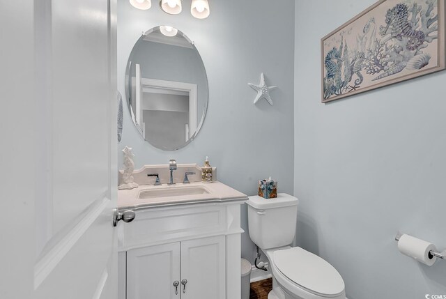 bathroom featuring crown molding, vanity, and toilet