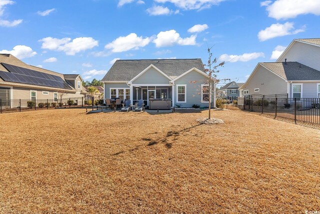 back of house with a hot tub and a patio