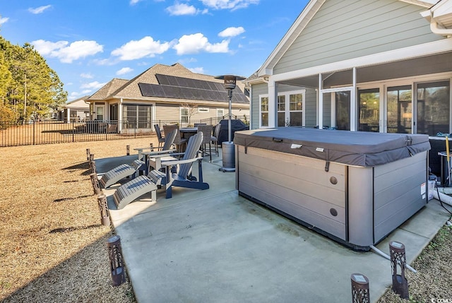 view of patio / terrace featuring a hot tub and a sunroom