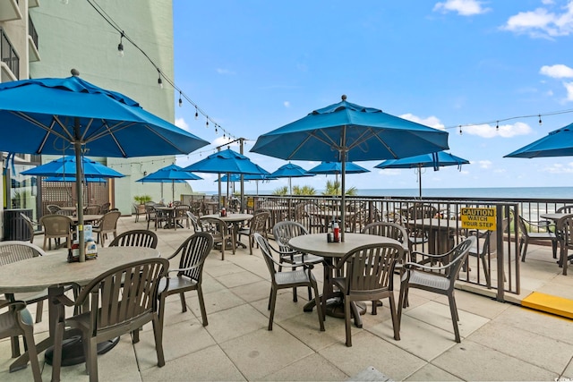 view of patio / terrace with a water view and a view of the beach