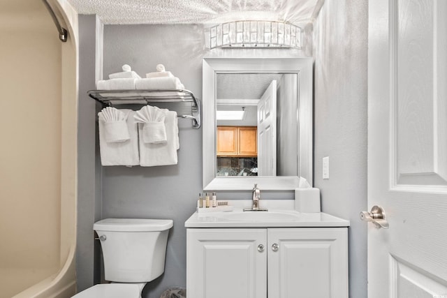 bathroom featuring vanity, toilet, and a textured ceiling