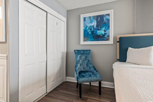 bedroom featuring dark hardwood / wood-style flooring, a closet, and a textured ceiling