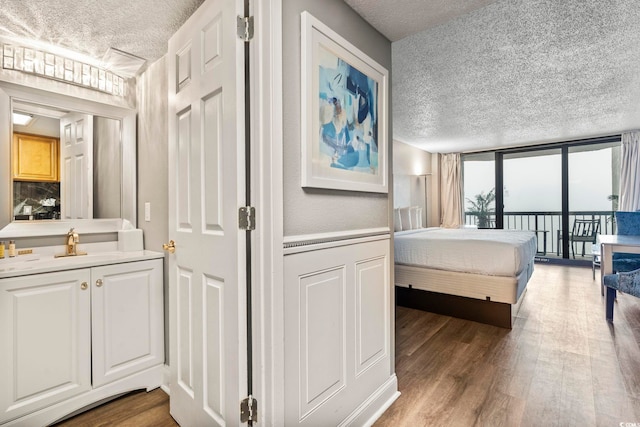 bedroom with access to exterior, dark wood-type flooring, and expansive windows