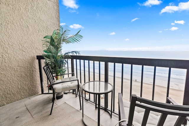 balcony featuring a water view and a view of the beach