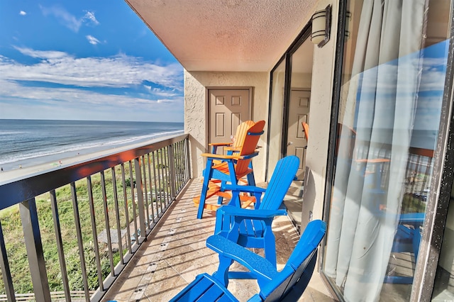 balcony with a water view and a beach view