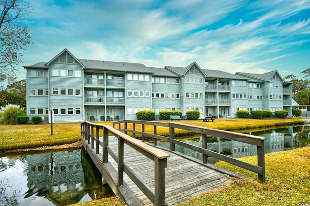 dock area with a water view and a lawn