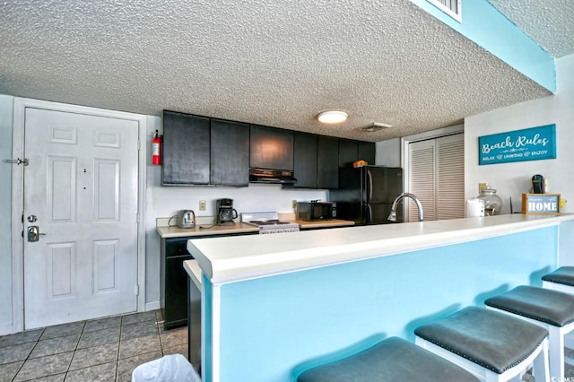 kitchen with range hood, black appliances, sink, a kitchen breakfast bar, and kitchen peninsula