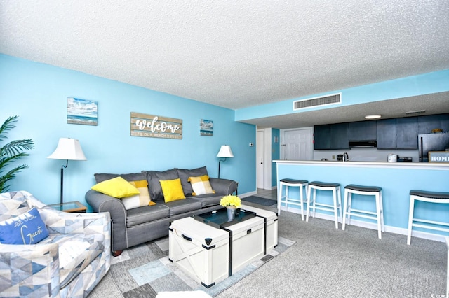 living room featuring light colored carpet and a textured ceiling