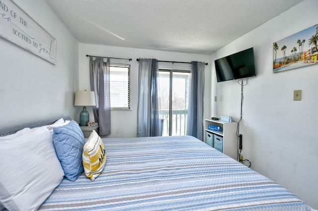 bedroom with access to exterior and a textured ceiling