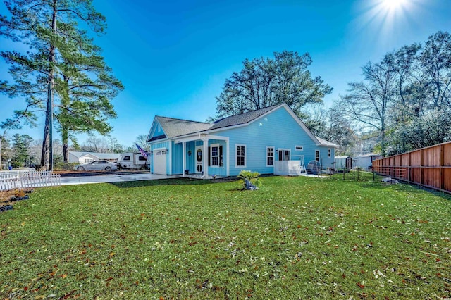 rear view of house with a garage and a lawn