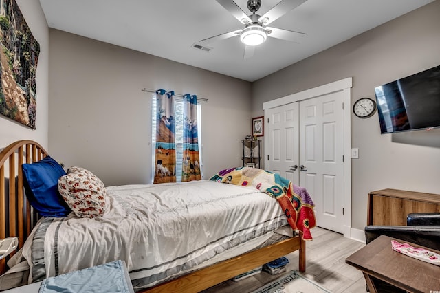 bedroom featuring ceiling fan, light hardwood / wood-style floors, and a closet