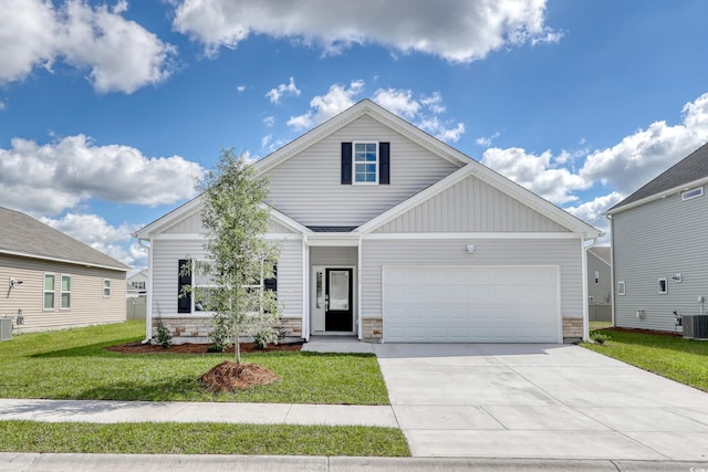 view of front of home with a front lawn, a garage, and cooling unit